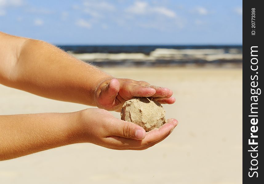 Small girl hands is keeping ball of sand. Small girl hands is keeping ball of sand.