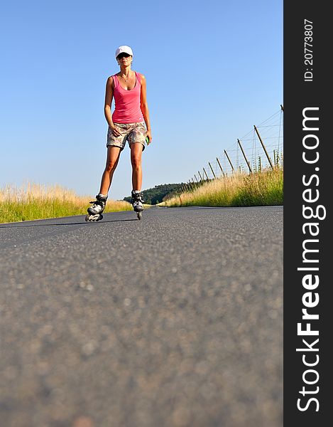Young woman rollerskating during the sunny day.