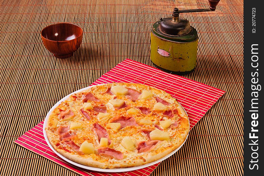 Italian salami pizza on table and pepper mill