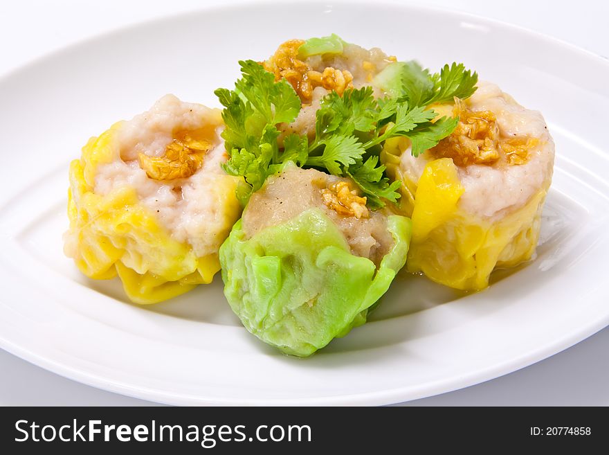 Steamed green and yellow dumplings topped with fried garlic