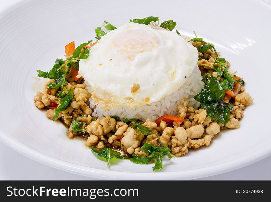 Chicken sauteed with garlic and hot basil set on steamed rice with fried egg