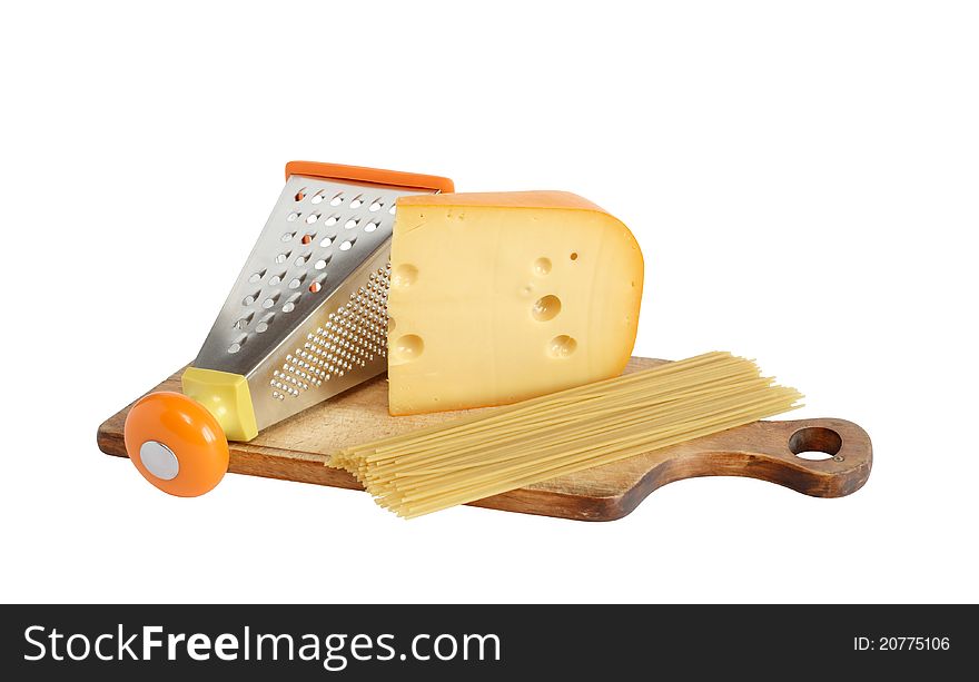 Raw spaghetti near grater and cheese on cutting board. Isolated on white with clipping path. Raw spaghetti near grater and cheese on cutting board. Isolated on white with clipping path