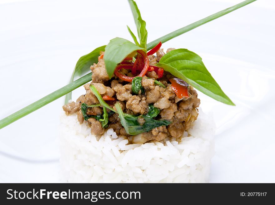 Spicy pork fried with hot basil on rice garnish with basil leaves