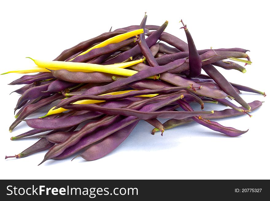 Pile of purple and yellow string beans isolated on white