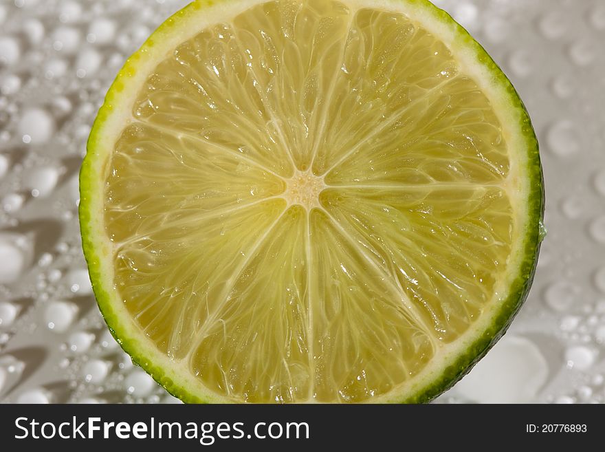 Lime with water drops on white