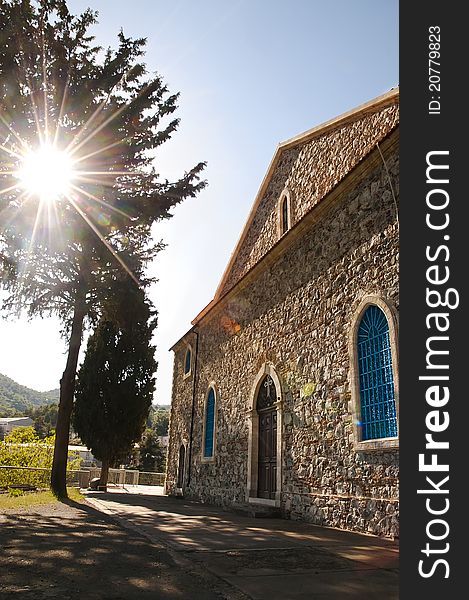 Sun shining through the tree onto a stone built Greek orthodox church in Agros village, Cyprus. Sun shining through the tree onto a stone built Greek orthodox church in Agros village, Cyprus.