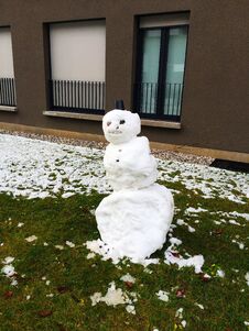 Snowman On The Green Grass In The Yard Of The House  Ljubljana  Slovenia. Stock Photos