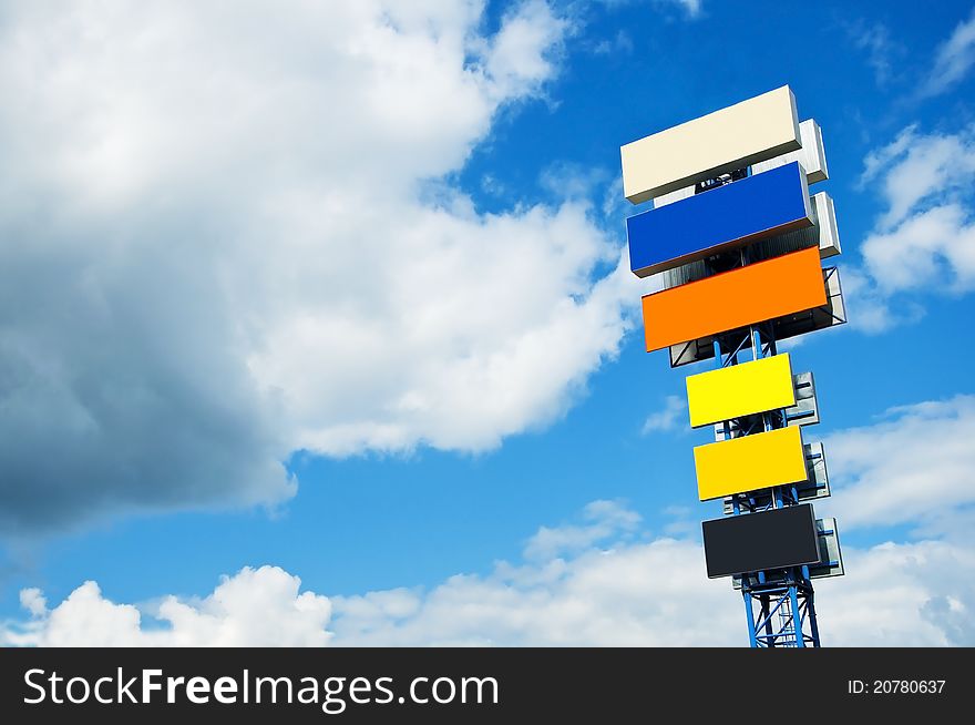 Ulti-coloured billboard on a background of the blue sky with clouds. Ulti-coloured billboard on a background of the blue sky with clouds