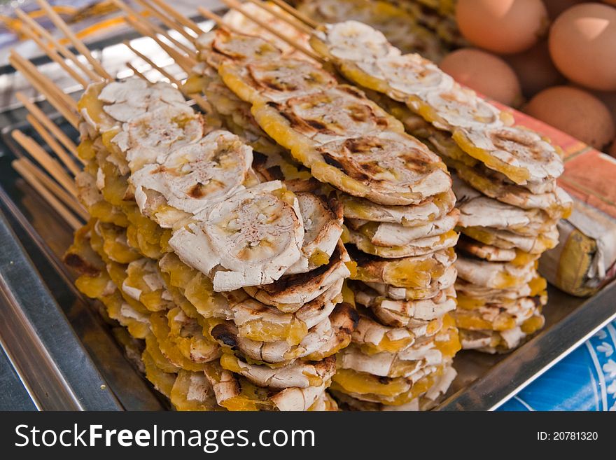 Pile of grilled bananas stack with wooden sticks tilted out. Pile of grilled bananas stack with wooden sticks tilted out