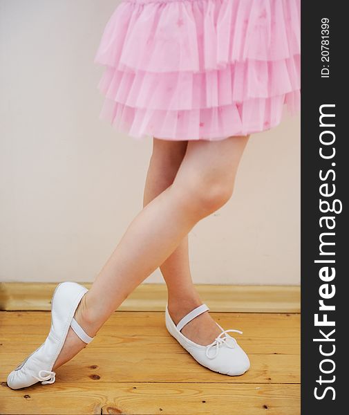 Yound ballerina's legs and feet in pink tutu dress. Yound ballerina's legs and feet in pink tutu dress