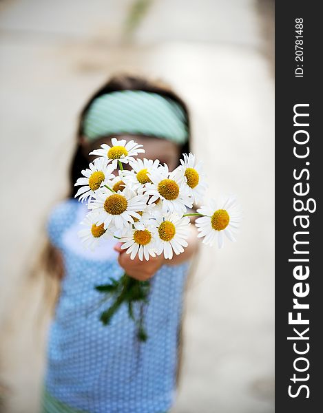 Outdoors portrait of a child girl with daisies