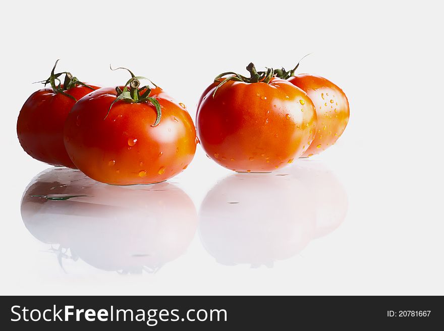 Fresh and wet biological tomatoes witrh reflaction on white.