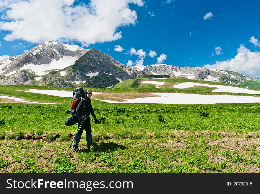 Tourist with a backpack on the background of snowy mountains. North Caucasus mountains