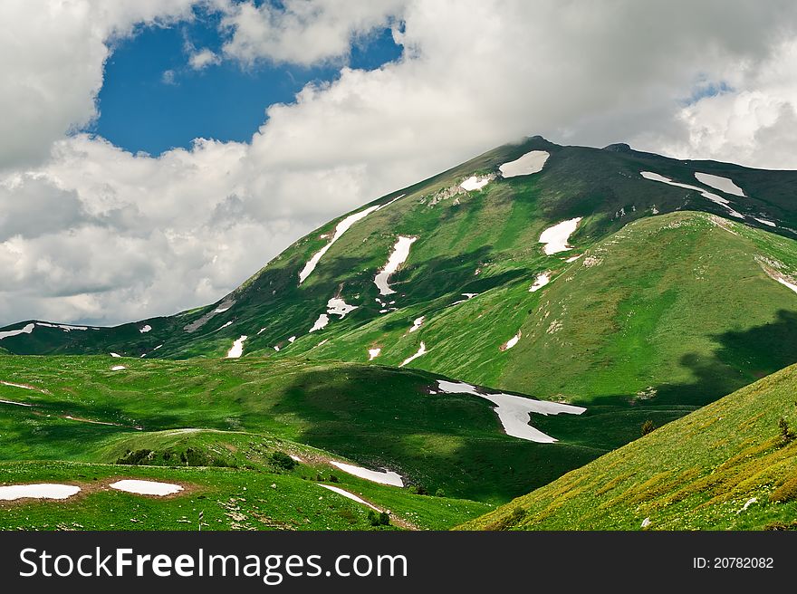 Summer landscape with green grass, mountains and clouds. mountains of North Caucasus. Summer landscape with green grass, mountains and clouds. mountains of North Caucasus