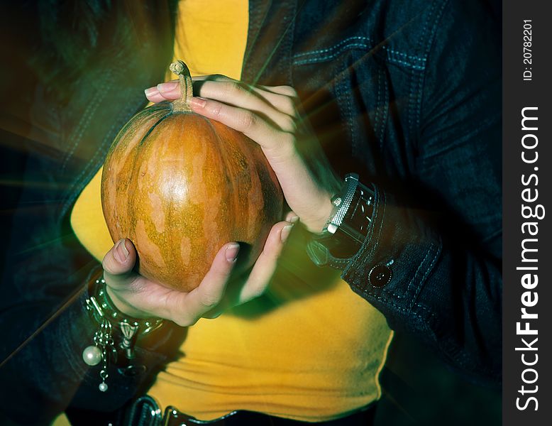 Woman holding halloween shining magic pumpkin