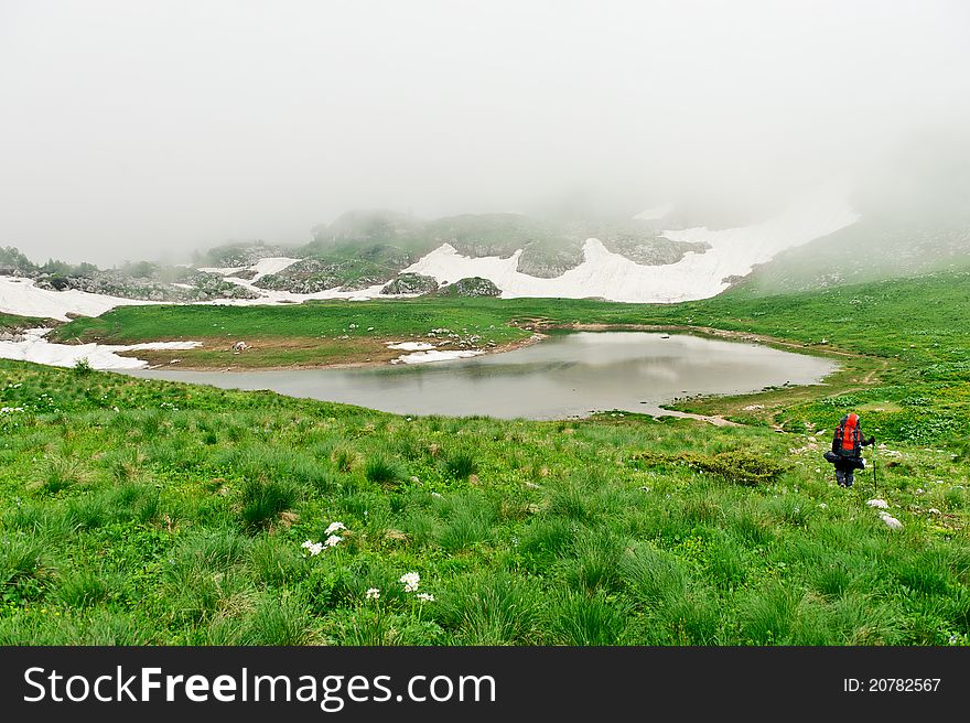 Tourist with a backpack walking along the road in the mountains. mountains of North Caucasus