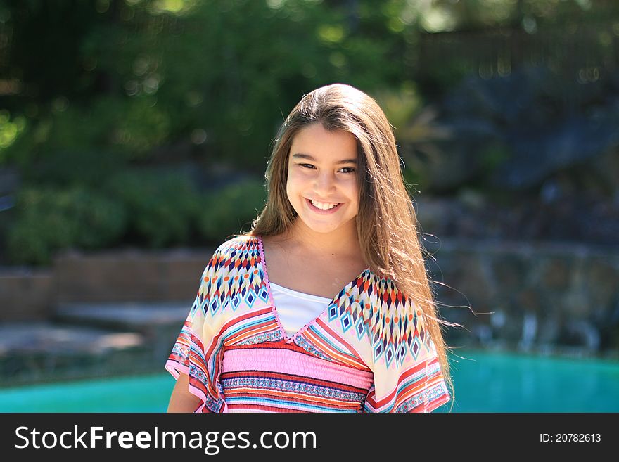 Cute smiling girl outdoors by the pool in summer