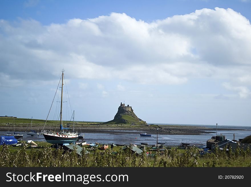 Lindisfarne castle nestling in background with fishermans boats in forground