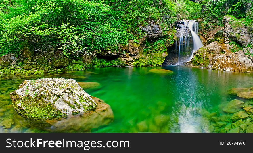 Beautiful waterfall falling into peaceful river