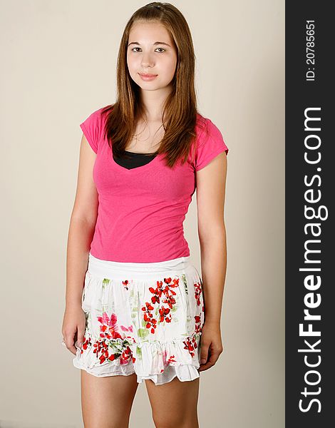 Thirteen year old girl poses wearing a pink shirt with a skirt. Thirteen year old girl poses wearing a pink shirt with a skirt.