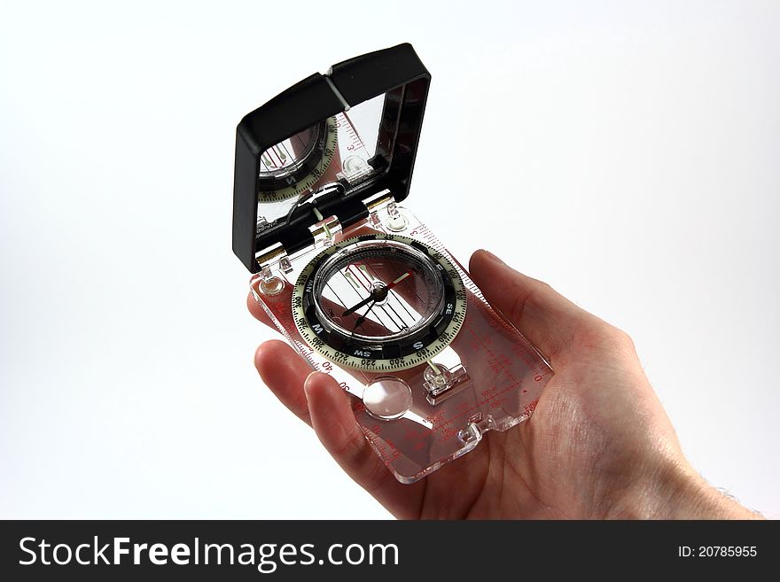 A modern compass held in a hand. A modern compass held in a hand.