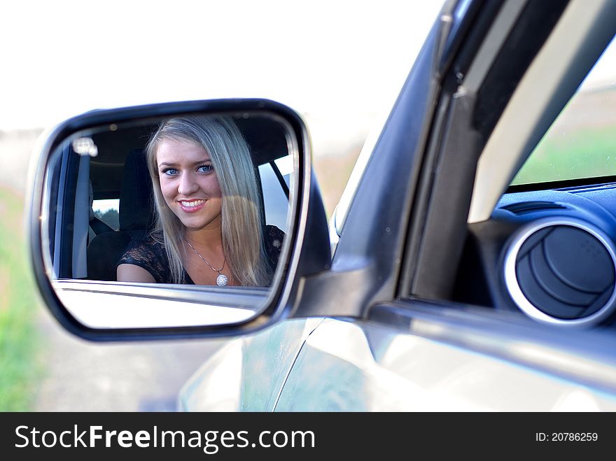 Beautiful girl in a car mirror. Beautiful girl in a car mirror