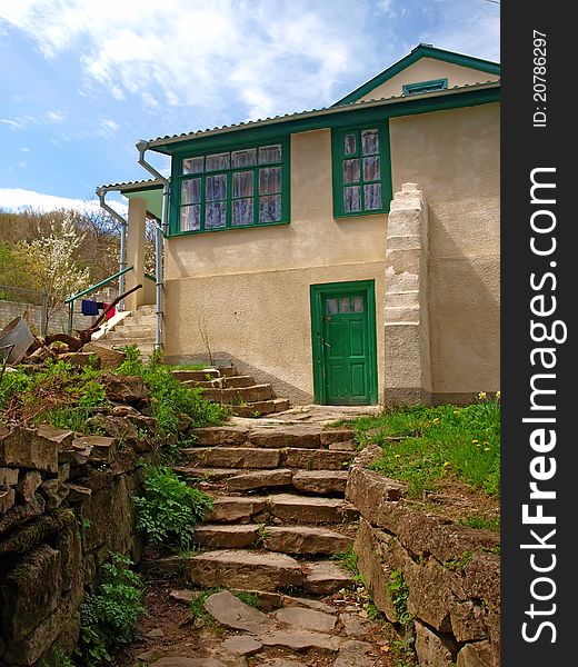 The old house with green windows, door and stony stairs. The old house with green windows, door and stony stairs