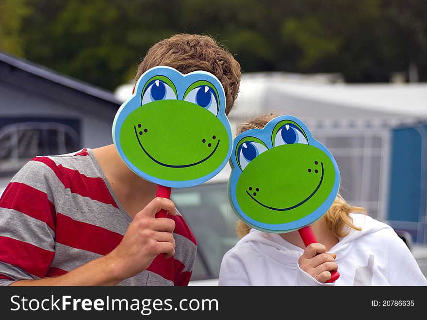 Boy and girl playing with frog masks. Boy and girl playing with frog masks