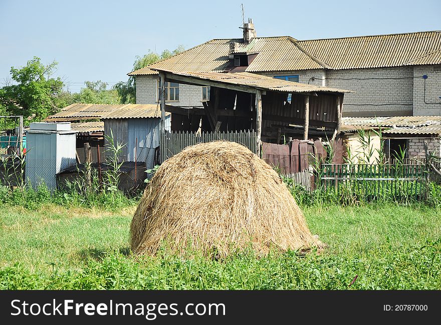A stack of hay outside the provincial household in a Ukrainian village. A stack of hay outside the provincial household in a Ukrainian village.