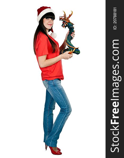 Girl in Santa hat with a decorative wooden dragon in the studio on a white background