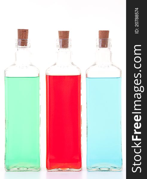 Three glass bottles with different colored liquids