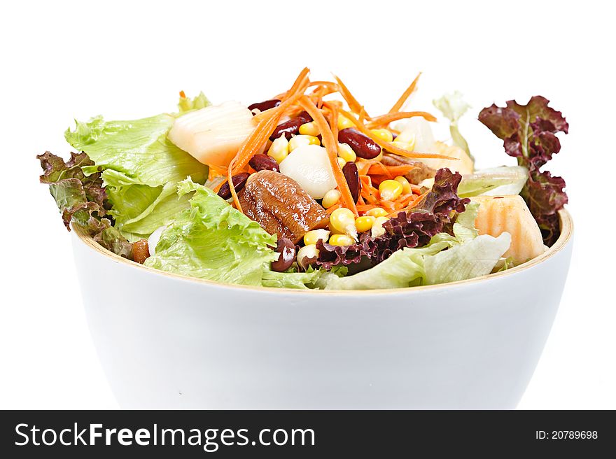 Mixed salad in salad bowl over white