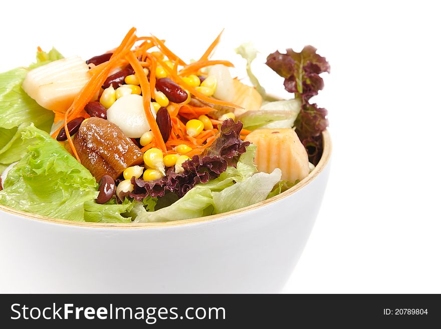 Mixed salad in salad bowl over white