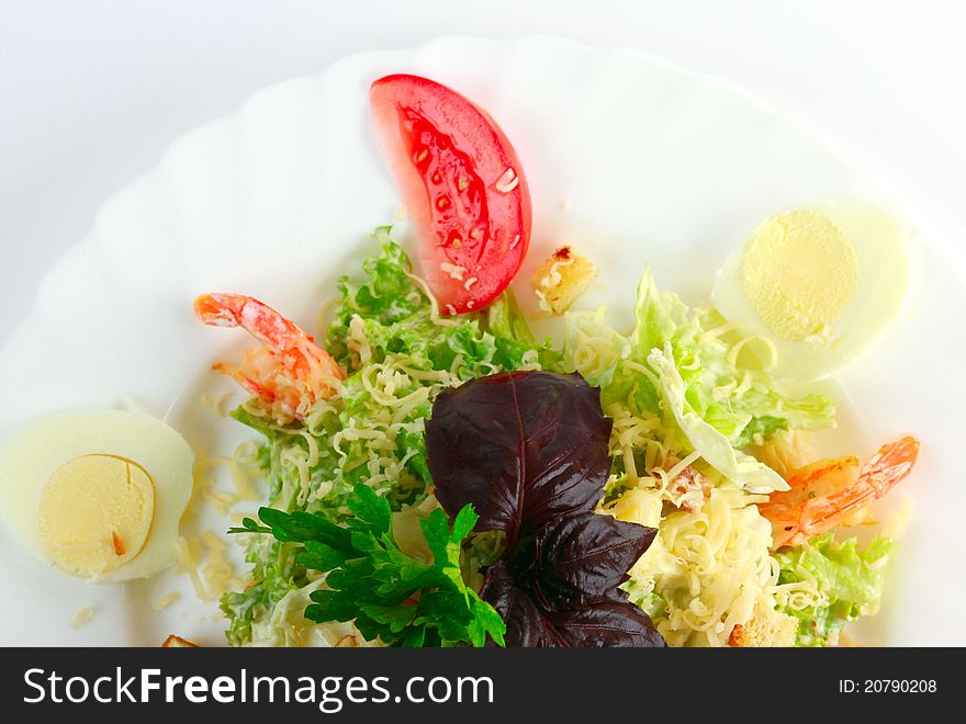 Caesar salad with shrimp on white plate