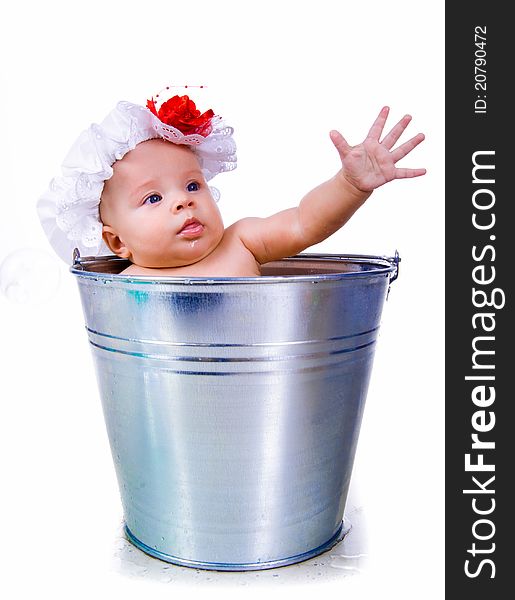 Little baby on a bucket on white background