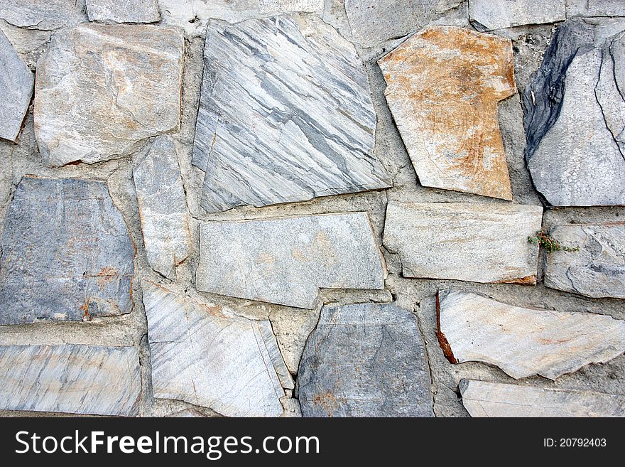 Fund of screen of a wall of gray stones with brown tones in a point of attention.