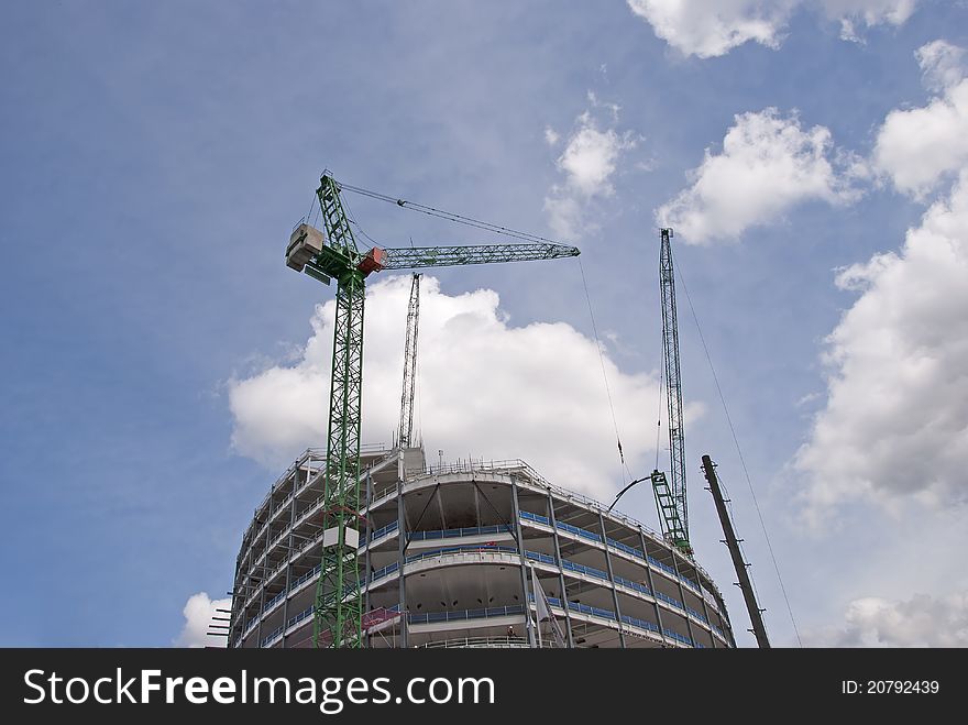 Two Tower Cranes on top of a new construction site lifting steel