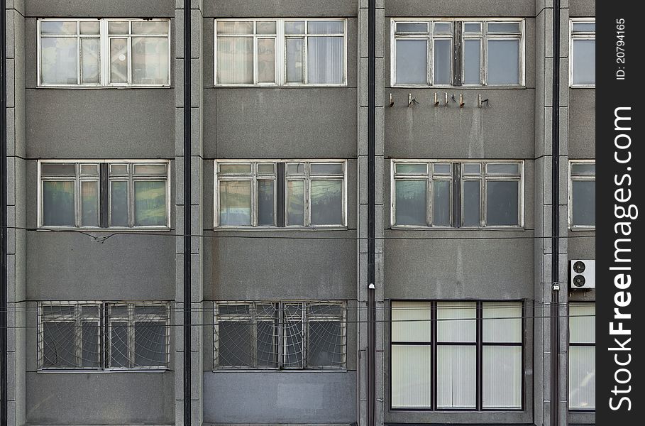 Photo of the grey building wall with nine windows and three halfs. Photo of the grey building wall with nine windows and three halfs