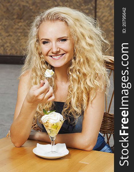 Portrait of young smiling girl eating the dessert in the cafe