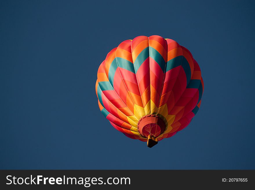 A colorful hot air balloon passes overhead. A colorful hot air balloon passes overhead