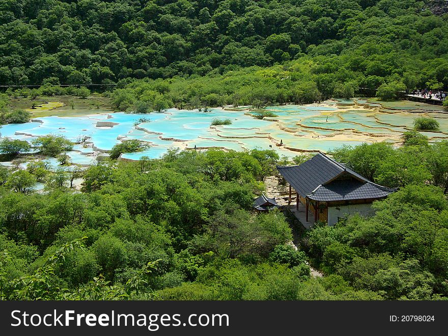 An ancient temple sits beside limestone pools in the valley. An ancient temple sits beside limestone pools in the valley.