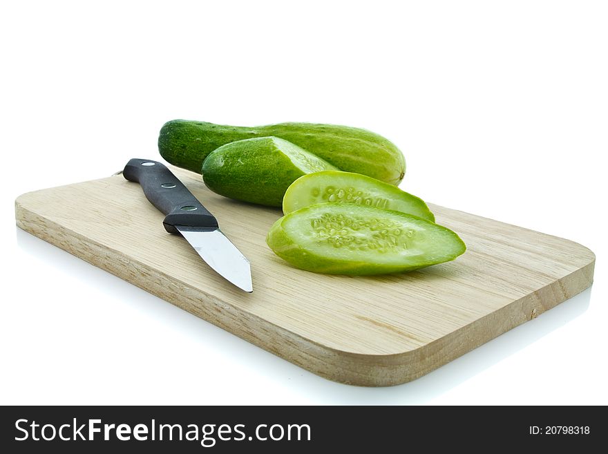 Cucumber sliced with knife on chopping board. Cucumber sliced with knife on chopping board