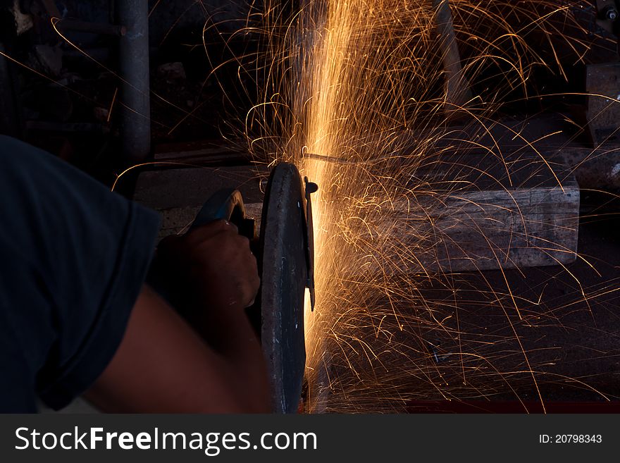 Man cutting steel with a small grinder