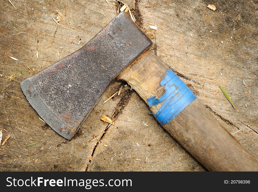 An old ax on a tree stump with woodchips. An old ax on a tree stump with woodchips