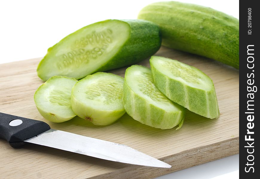 Cucumbers and knife on chopping board. Cucumbers and knife on chopping board
