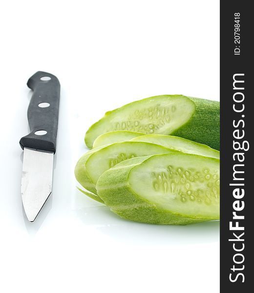 Sliced cucumber with knife on white background