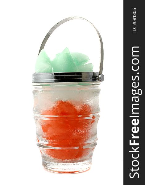 Green, red and white ice cubes put in a glass jug with metal handle. Green, red and white ice cubes put in a glass jug with metal handle