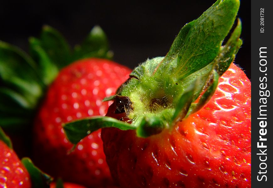 A close up of a strawberry, with green leaves too. A close up of a strawberry, with green leaves too.