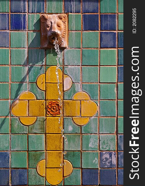 Colorful tile fountain with lion and cross