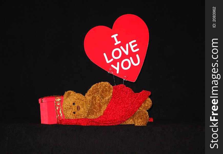Teddy bear with red cloth across lap and sign of love. Teddy bear with red cloth across lap and sign of love